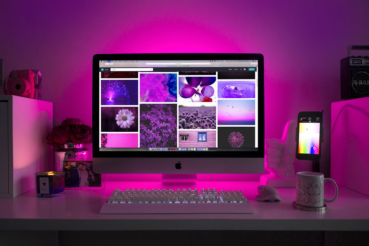 services-02 Modern desk setup with neon lighting and a desktop computer displaying colorful images.